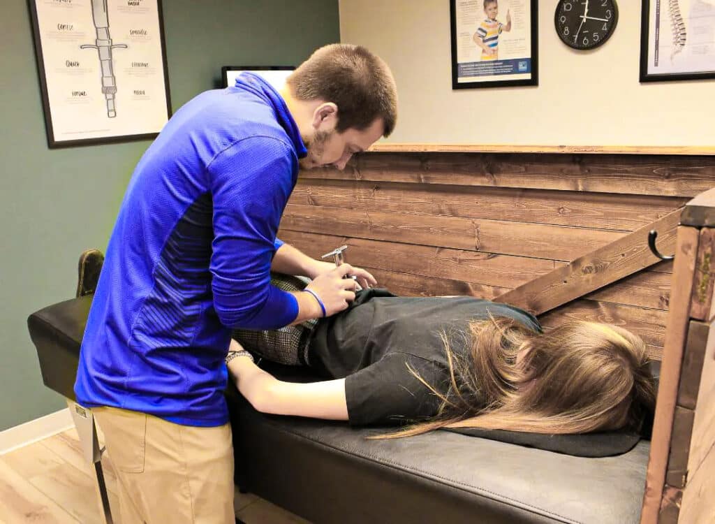 Dr Zach in Eau Claire Helping a patient with chiropractic care.