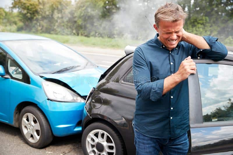 Car accident chiropractic care patient holding his neck from whiplash after an accident.