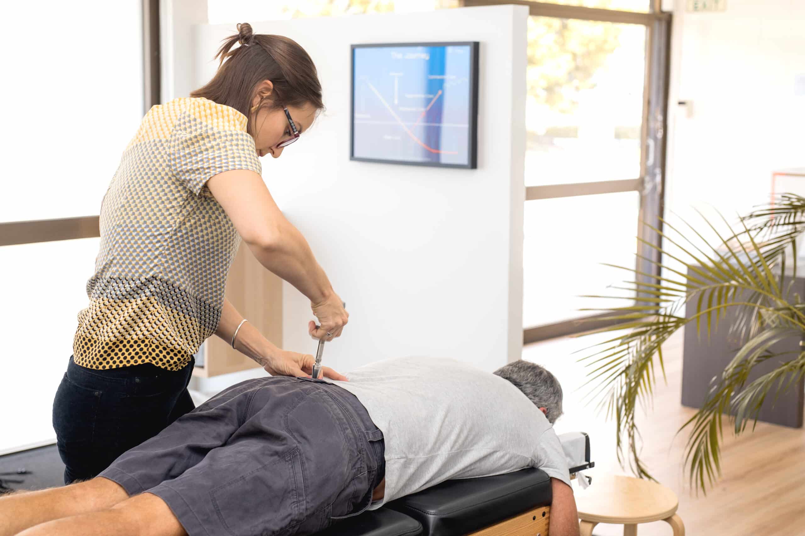 Doctor of chiropractic showing a patient the benefits of torque release technique.