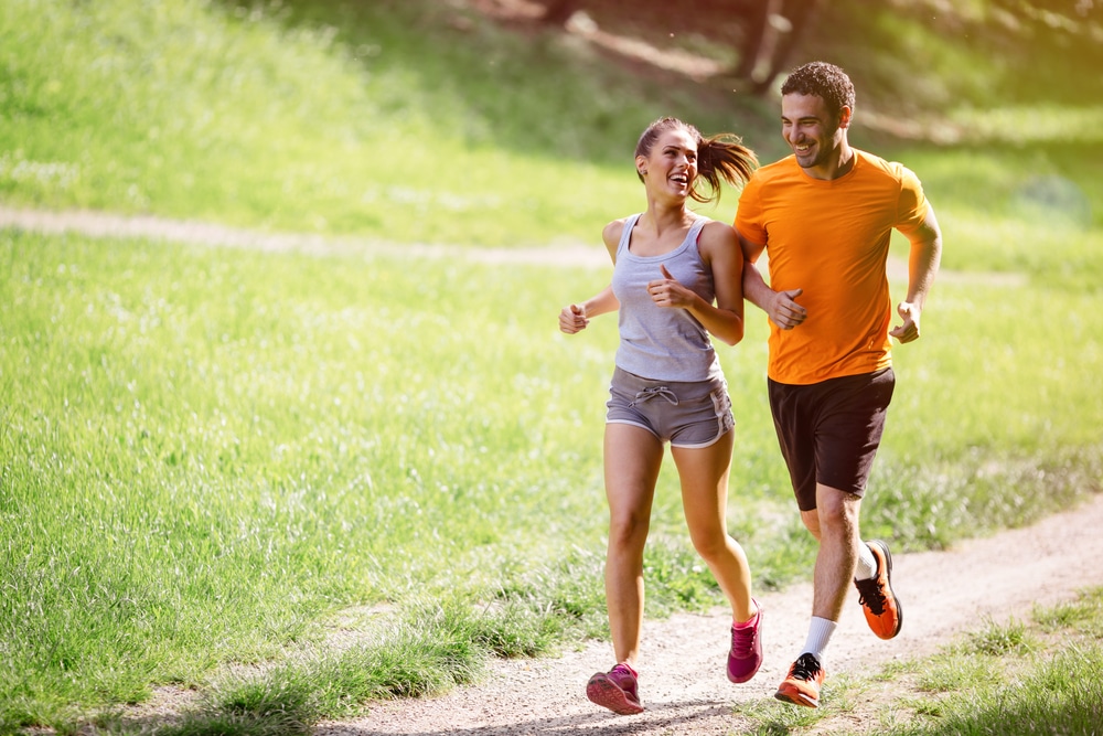 Healthy couple running talking about getting spine adjustments to relieve pain.