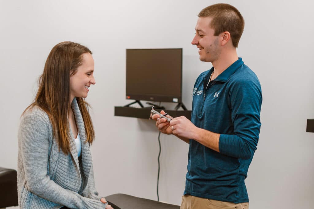 Chiropractor explaining the torque release technique to a patient sitting down.