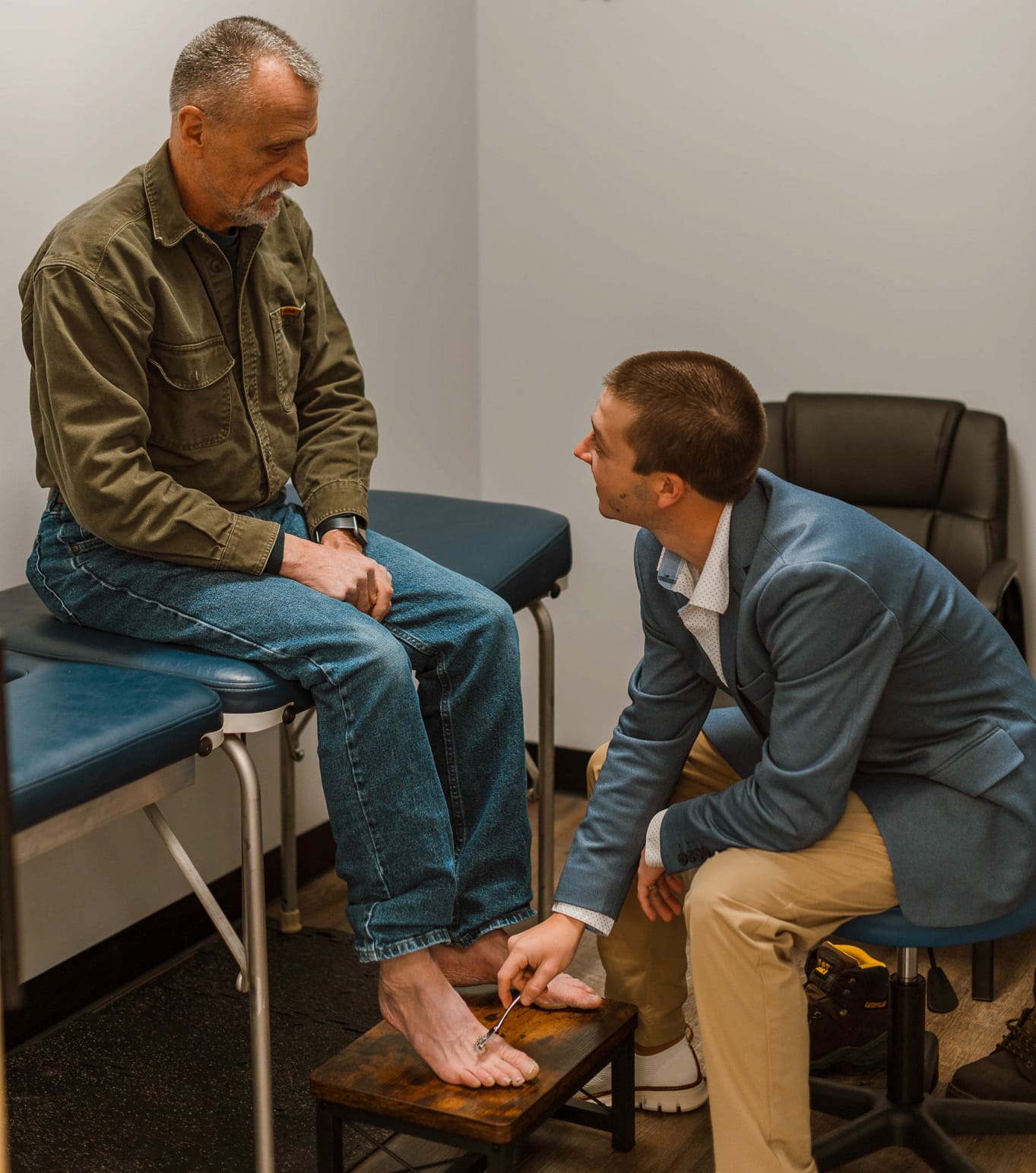 Dr. Zach Bruley is doing a chiropractic care examination on an elderly patient in Eau Claire.