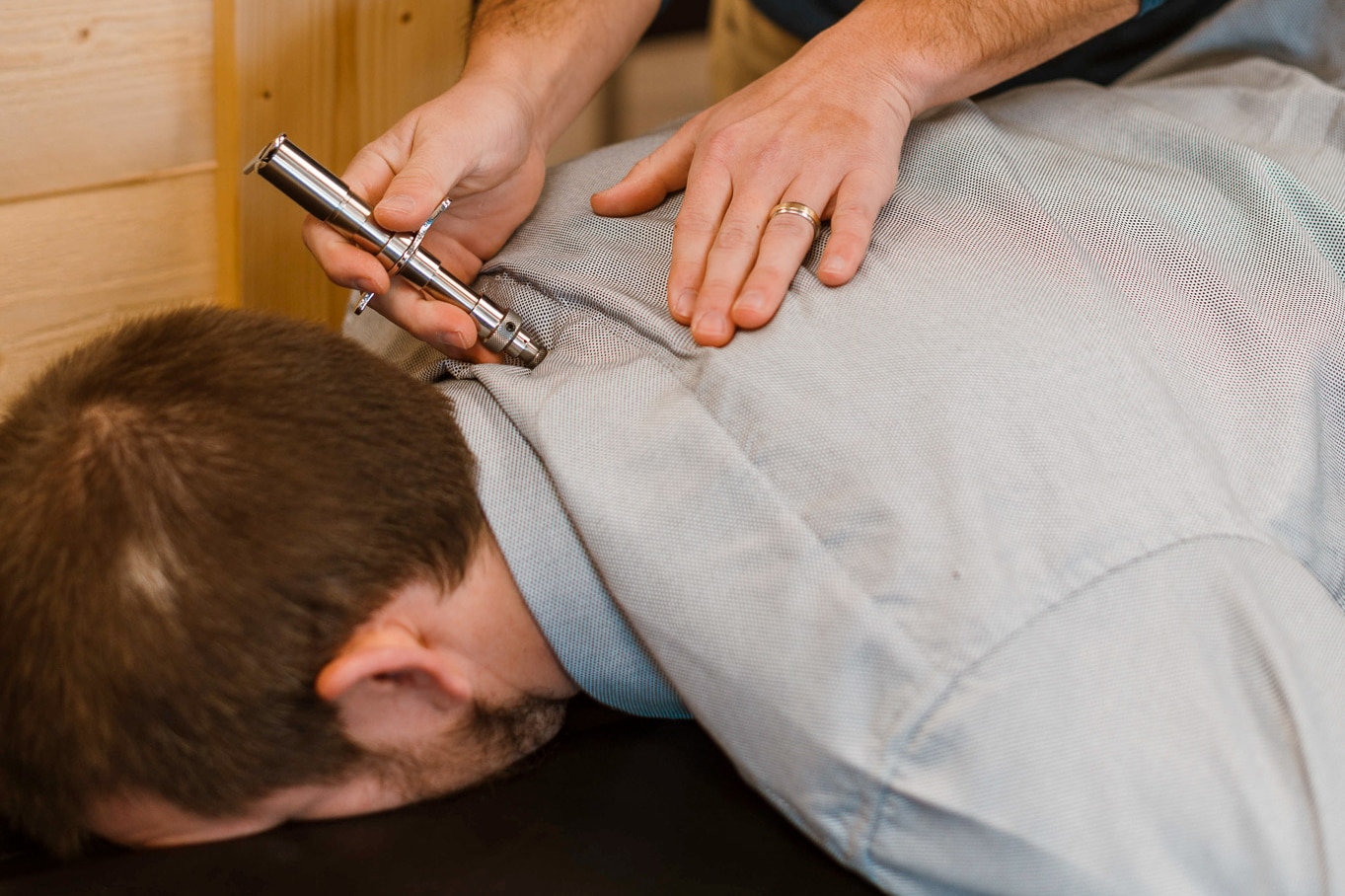 Chiropractor using a tool to help a patients neuropathy in Eau Claire.